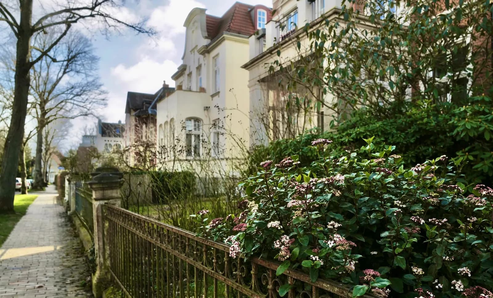 Altbauvillen mit Vorgärten hinter einem schmiedeeisernen Zaun in Lübeck-St. Jürgen