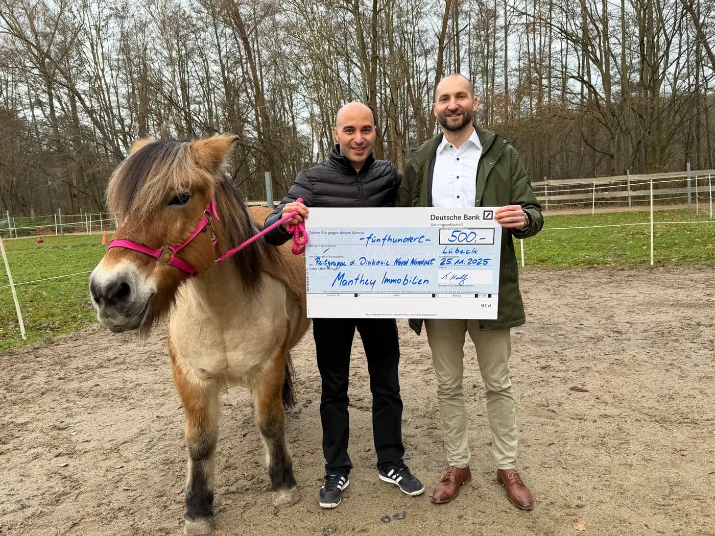 Thomas Manthey bei der Spendenübergabe: ein Scheck über 500 Euro an die Reitgruppe der Diakonie Nord Nordost in Lübeck, neben einem Therapie-Pony auf der Koppel